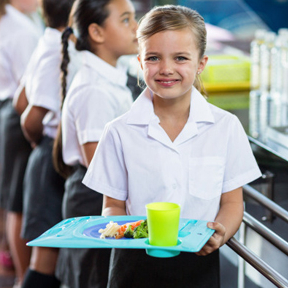 chłopiec trzymający tacę z jedzeniem