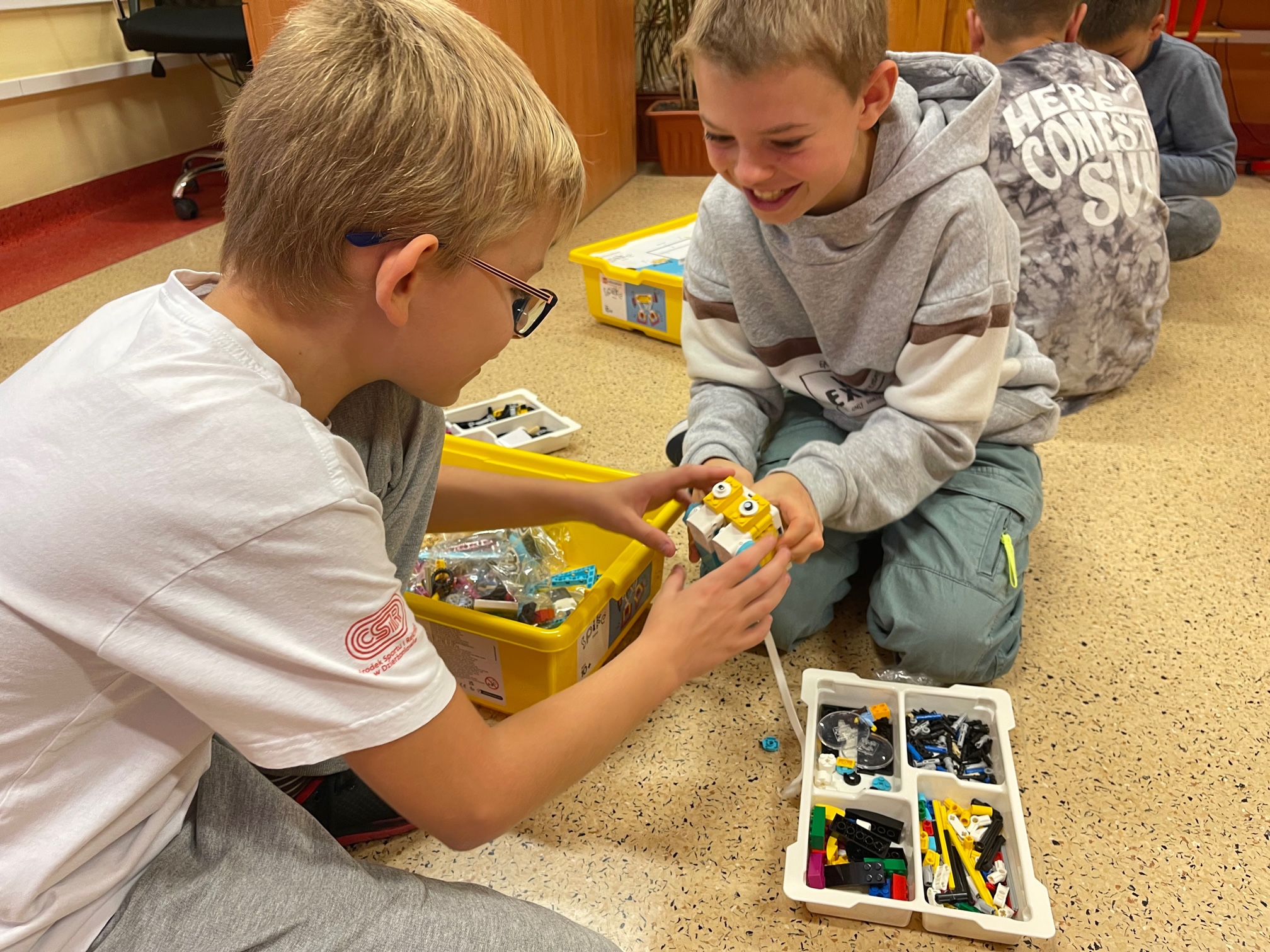 uczniowie budujący roboty lego