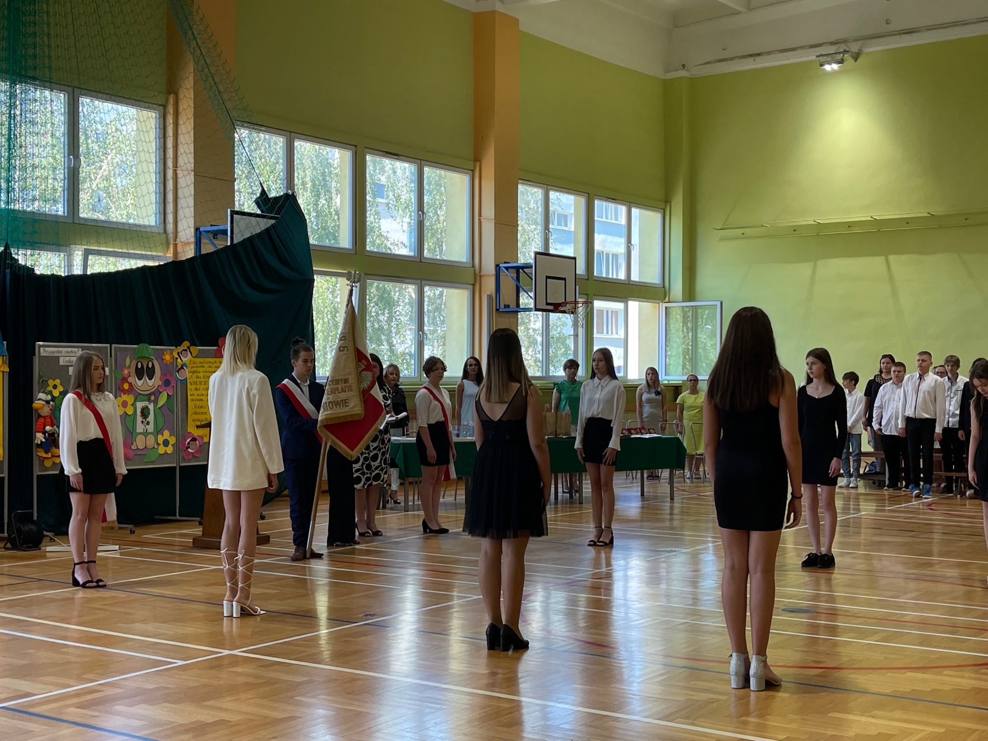 Uczniowie klas 8 wygłaszją  ślubowanie ns sali gimnastycznej